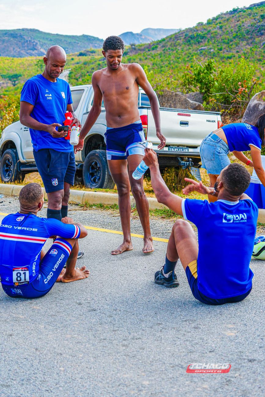 A delegação de Cabo Verde à beira da estrada no fim de uma etapa, com a equipa técnica a distribuir água